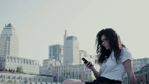 Young woman stting and using her mobile Stock Footage 83491541