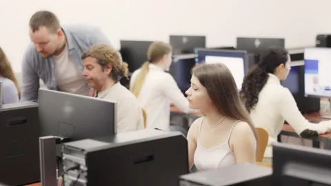 Young woman student of computer courses looks at monitor screen, types on Stock Footage 341525683