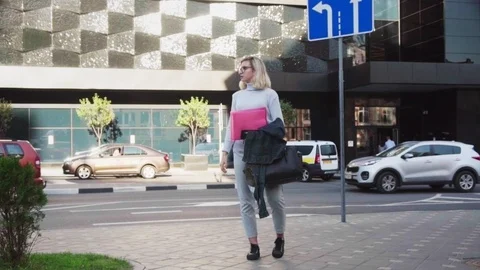 Young woman student standing with folder and looking for job on urban street Stock Footage 97408129