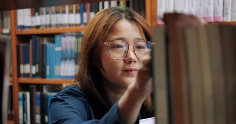 Young woman studies in a library Video stock 341187380