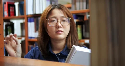 Young woman studies in a library Video stock 341193592