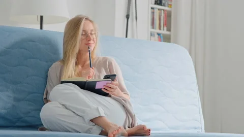 Young woman study on sofa with notebook and phone Video stock 132047759