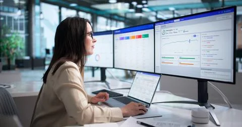 Young Woman Studying Client Data On Laptop To Improve Retention Rates. Stock Photos