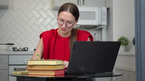 Young woman studying online using laptop and books at home Stock-Footage 307309255