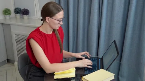 Young woman studying online using laptop and books at home Видео 307311042