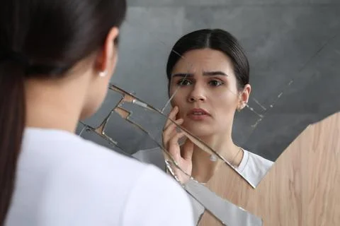 Young woman suffering from mental problems near broken mirror indoors Stock Photos