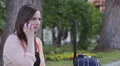 a young woman with a suitcase is on the phone and she is laughing with joy HD Footage