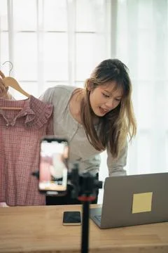 Young woman with surprised expression using laptop computer at home with cl.. Stock Photos