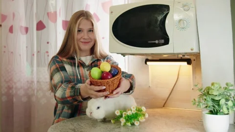 Young woman surrounded by Easter eggs and floral arrangements Video stock 330492504