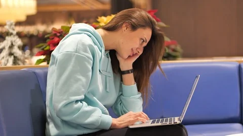 A young woman in a sweatshirt develops an application, she smiles clicks on a Stock Footage 121494833