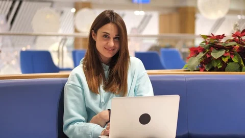 Young woman in a sweatshirt develops an application, she clicks on a laptop and Stock Footage 121562265