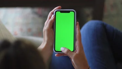 Young Woman Swiping On Her iPhone - Green Screen Stock Footage