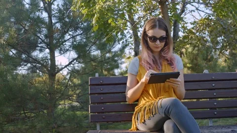 Young woman with tablet on the bench Stock Footage 72249154