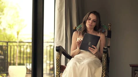 Young woman with tablet computer sitting on swing chair HD Video stock 42277400