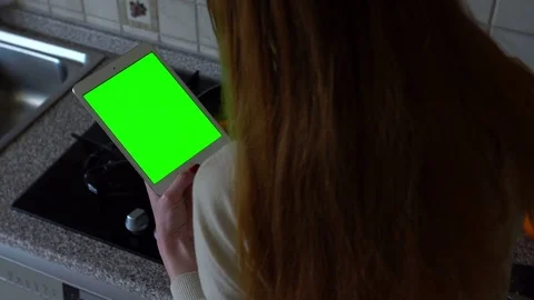 Young woman with tablet computer standing in kitchen. Green screen Stock Footage 73532013