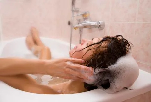 Young woman takes a bath with shampoo Stock Photos