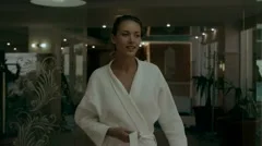 Young woman takes off bathrobe on the wa, Stock Video