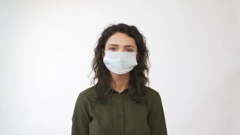 Young woman takes off medical mask. Breathes deeply and smiling looking at camer Stock Footage