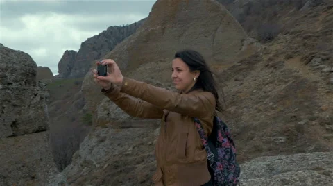 A young woman takes on the smartphone with the surrounding mountain landscape Stock Footage 59082744