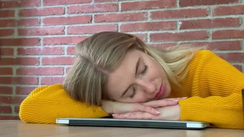 A young woman is taking a much-needed rest, sleeping peacefully on her closed la Stock Footage 335240763