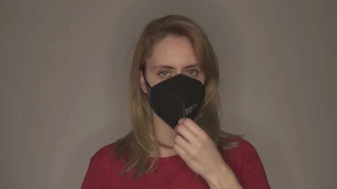 Young woman taking off multiple face masks Stock Footage 146698664