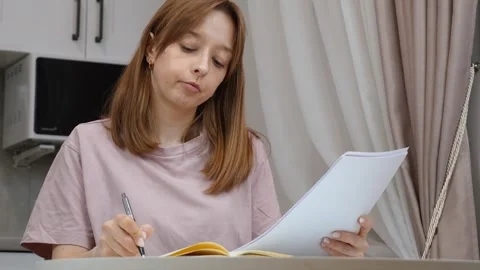 Young woman taking notes from documents at home Stock Footage 314622639
