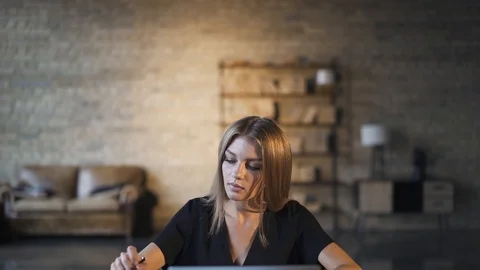 Young woman taking notes while using laptop at home Video stock 115215449