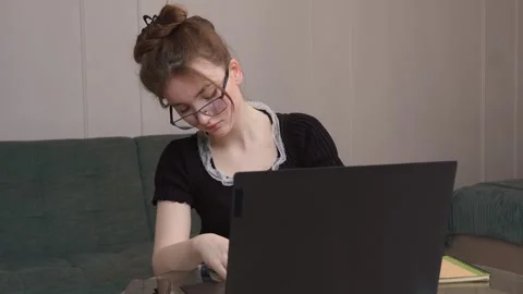 Young woman taking notes while studying online at home Stock Footage 311781618