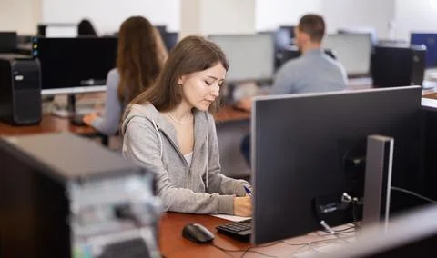 Young woman taking notes while working at computer Foto stock