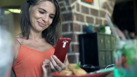 Young woman taking photo of food and drink with cellphone sitting in cafe Stock Footage