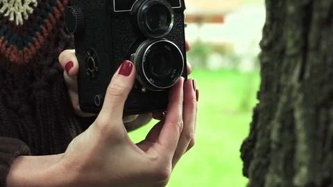 Young woman is taking photos on a old vintage film camera at the autumn park. HD Stock Footage