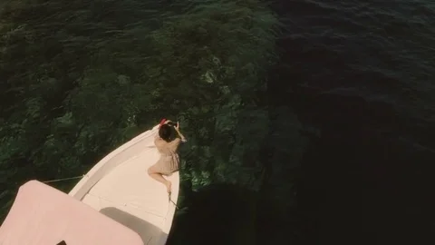 Young woman taking pictures with her smartphone on a red boat in the middle of Stock Footage