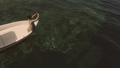 Young woman taking pictures with her smartphone on a red boat in the middle of Stock Footage