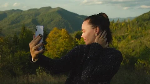 Young woman taking selfies using mobile phone standing on top of mountain peak Stock Footage 269501645