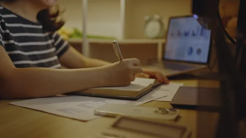 Young woman taking teaching notes and doing homework in the middle of the nig Stock Footage 251774696