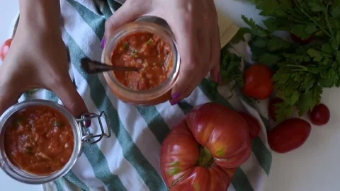 Young woman taking two jars of tomato salsa sauce top view Stock Footage 78595607