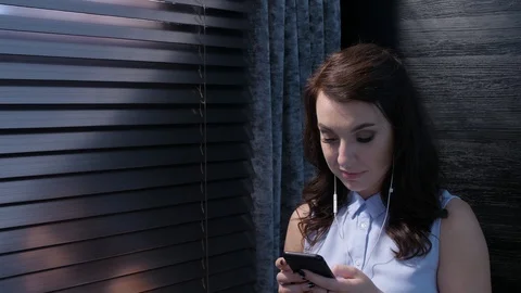 A young woman is talking on her mobile phone and sending SMS messages. It is at Stock Footage 92735853