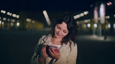 Young woman talking on the phone on the background of night city Stock Footage