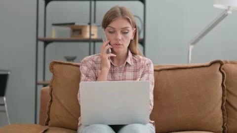 Young Woman Talking on phone while Using Laptop Outdoor Stock Footage 287922073