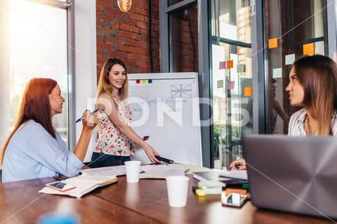 Young woman teaching English to adult students at language school Stock Photos