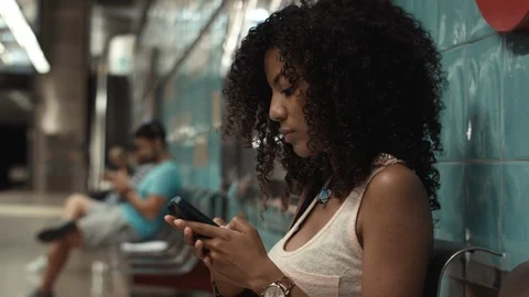 Young woman texting on his smartphone, while waiting for the metro. Stock Footage