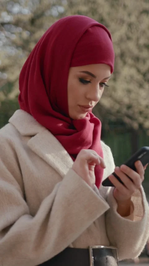A Young Woman is Texting Outdoors while Dressed in Stylish Casual Attire Stock Footage 313781895