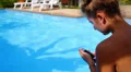 Young Woman Texting on the Phone while Relaxing in Private Pool near Luxury HD Footage