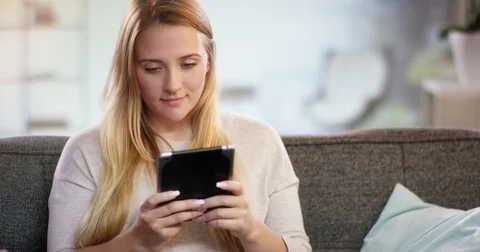 Young woman texting something on a tablet Stock Footage 78562676