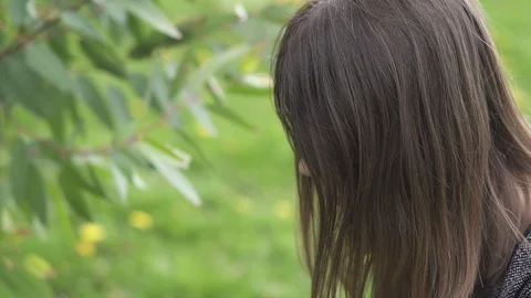 Young Woman Texting while Holding a Yellow Flower at a Park, Spring Time, Slo Stock Footage 106791170