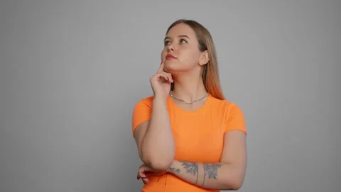 Young woman thinking to solve a problem. Isolated girl thoughtfully at idea hold Video stock 268306236