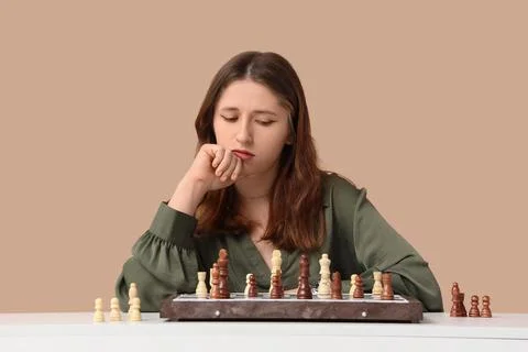 Young woman thinking while playing chess Stock Photos
