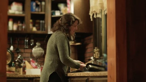 Young woman thinks of something amusing while doing dishes in her kitchen Stock Footage 101545777