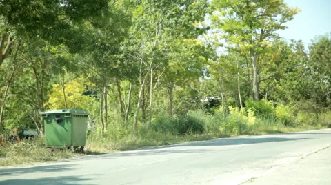 A young woman throws a garbage to bin on the road Stock Footage 69066784