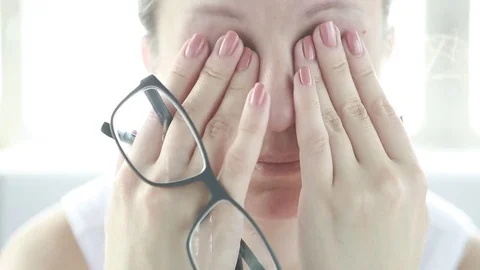 Young woman is tired and feels stressed out. Frustrated, she closed eyes and mas Stock Footage